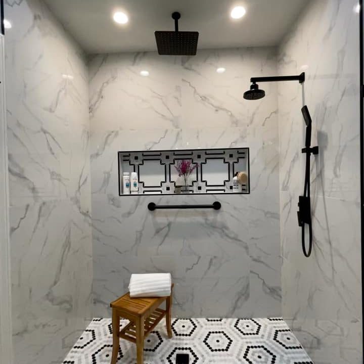 ceiling-tiled bathroom, black rain showers, a chair with a white towel