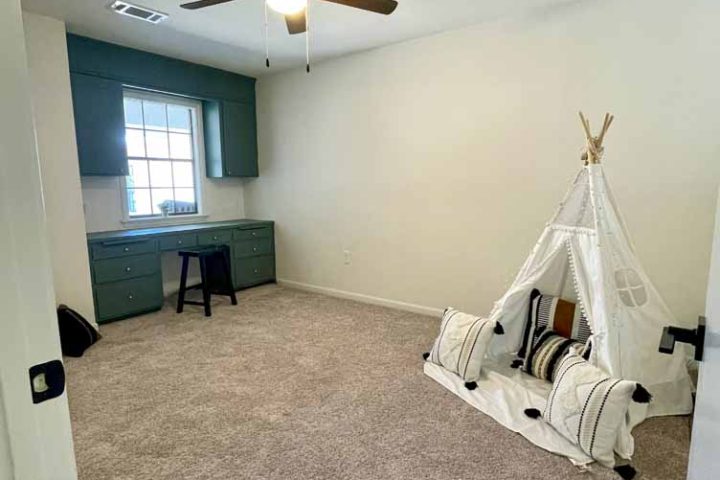 kids' room with study table, cabinet, and a teepee hut play area