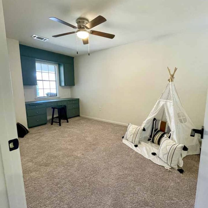kids' room with study table, cabinet, and a teepee hut play area